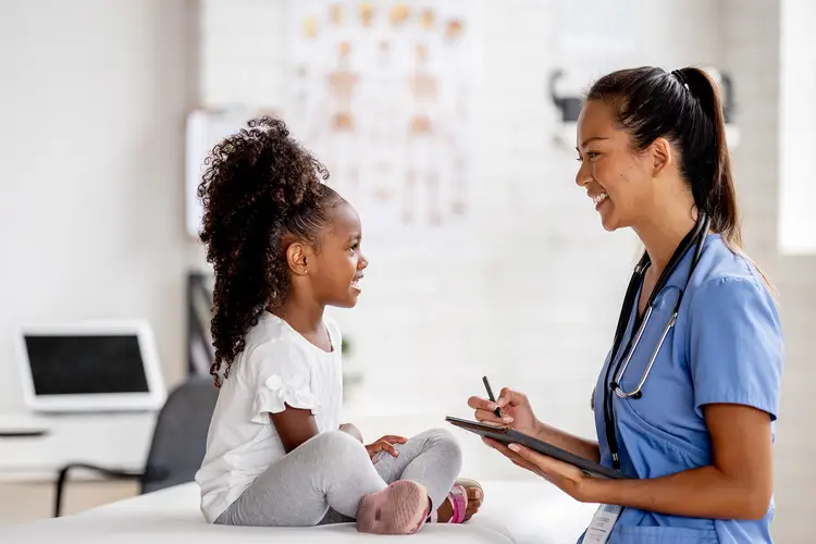 photo of young girl talking with pediatrician