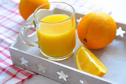 photo of glass of orange juice on serving tray