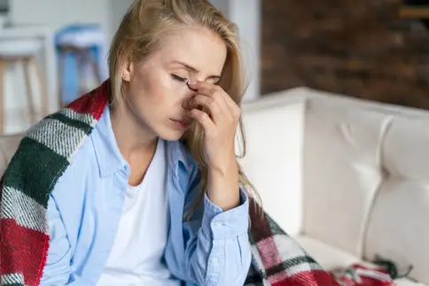 photo of a woman sitting on couch with a blanket s
