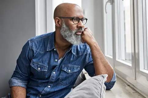 photo of thoughtful man looking out window
