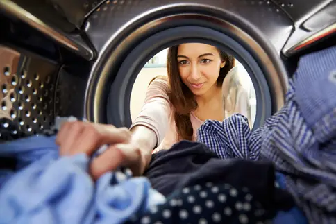 photo of woman pulling clothes out of dryer