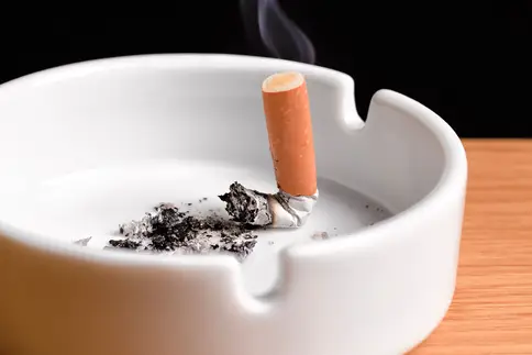 photo of cigarette butt smoldering in ashtray