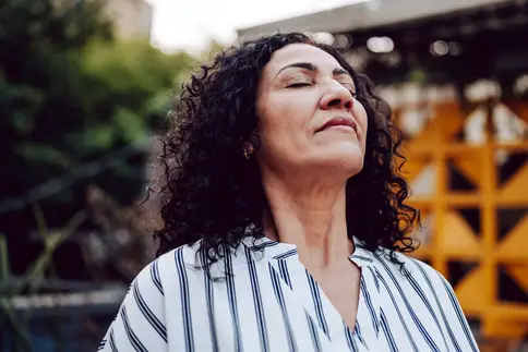 photo of mature woman meditating outdoors