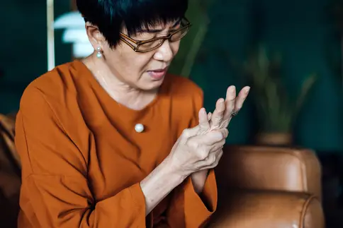 photo of mature woman rubbing her sore hand