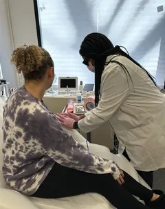 Regina providing care for a patient in the clinic.