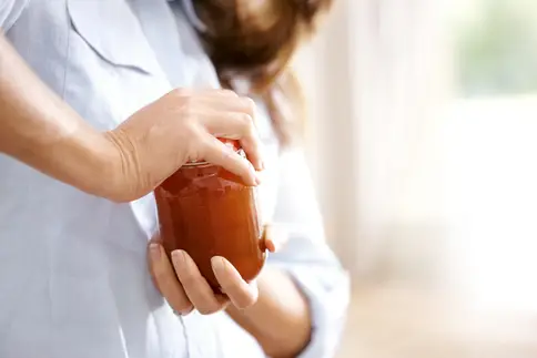 photo of woman opening jar