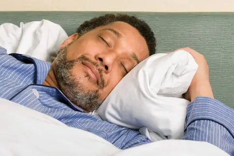 man asleep in bed