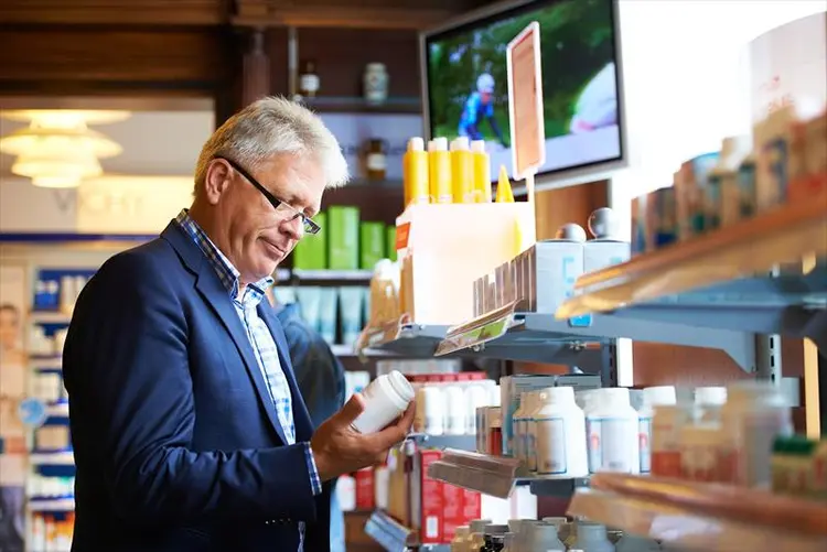 photo of man reading bottle label