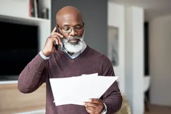 Senior man discussing medical bills on smartphone