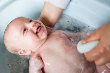Always keep a hand on your baby during bath time. Have any supplies you may need within reach. (Photo credit: Westend61/Getty Images)