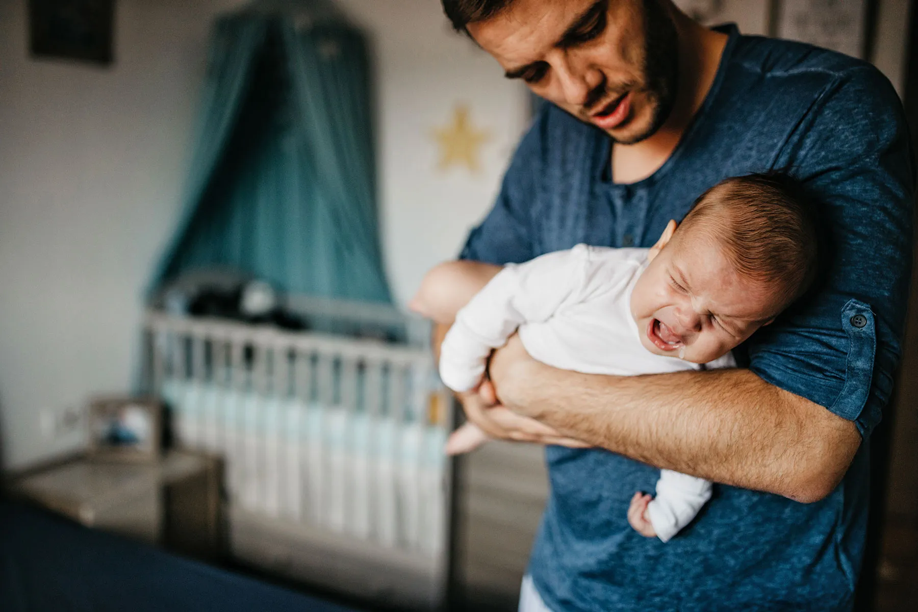 photo of crying baby in the colic carry