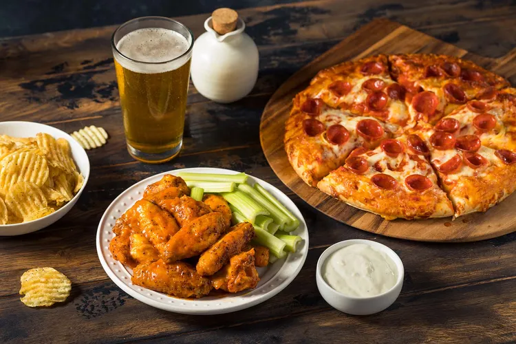 Spicy foods like wings and greasy foods like pizza are common triggers for heartburn. (Photo Credit: iStock / Getty Images)