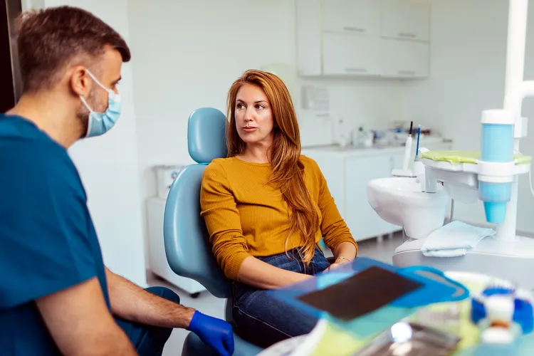photo of dentist talking with female patient