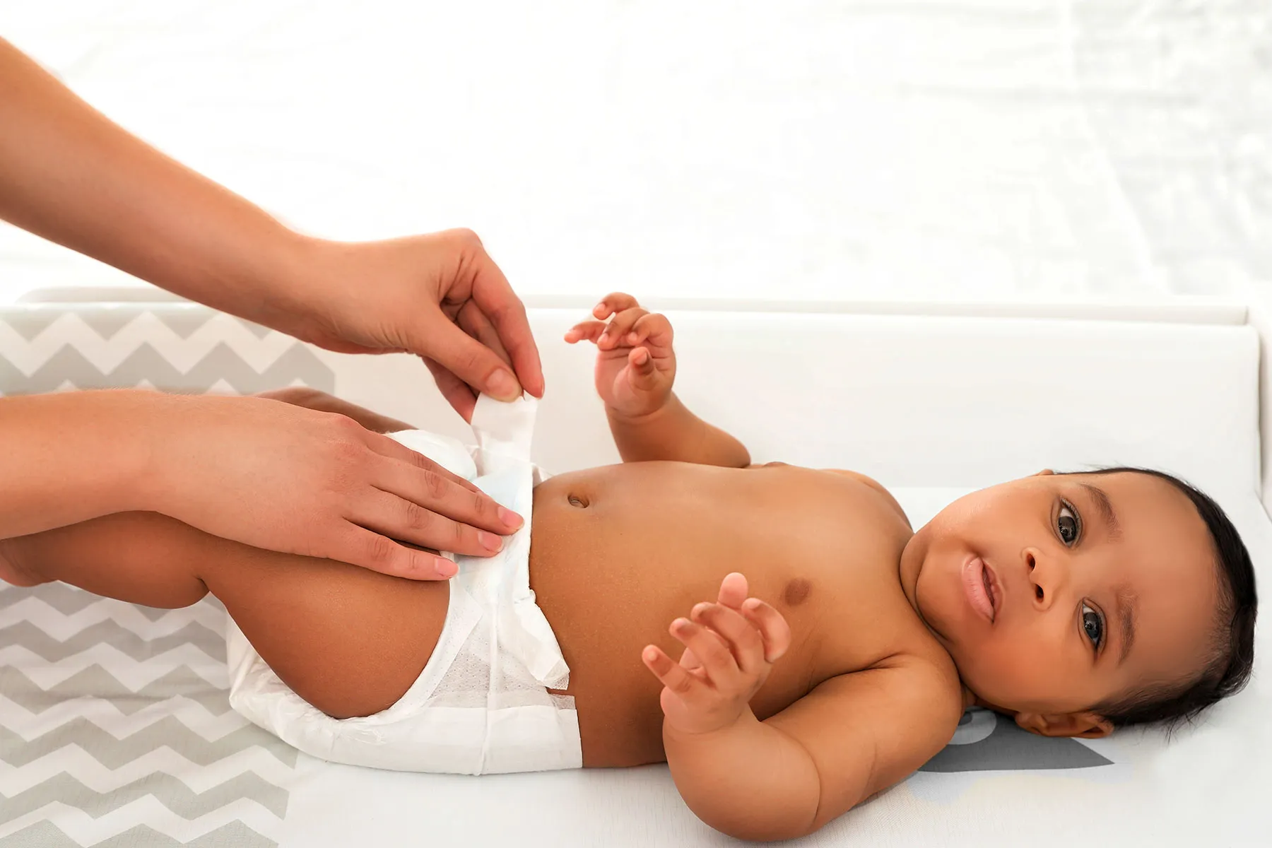 photo of Mother changing her baby's diaper.