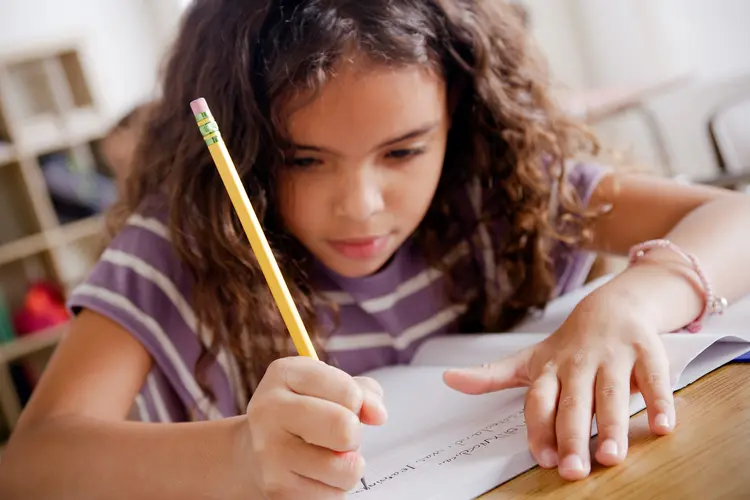 photo of schoolgirl writing in class
