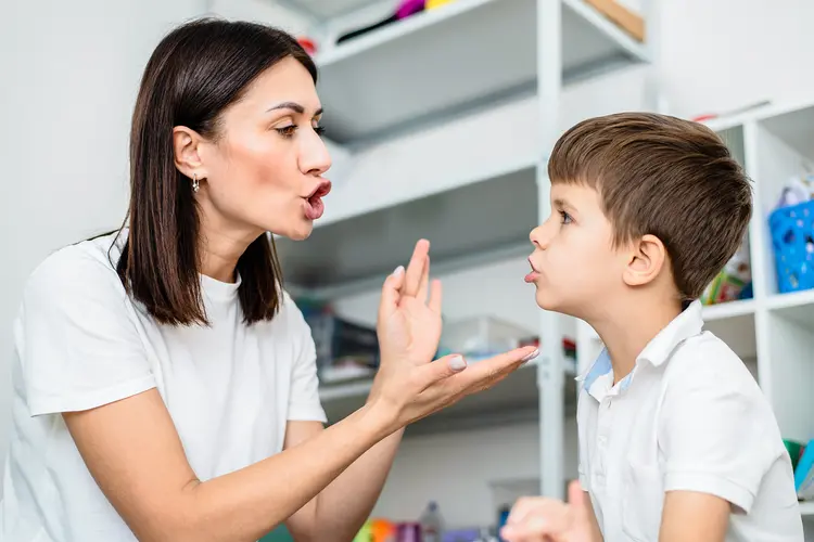 photo of therapist teaching correct pronunciation to boy