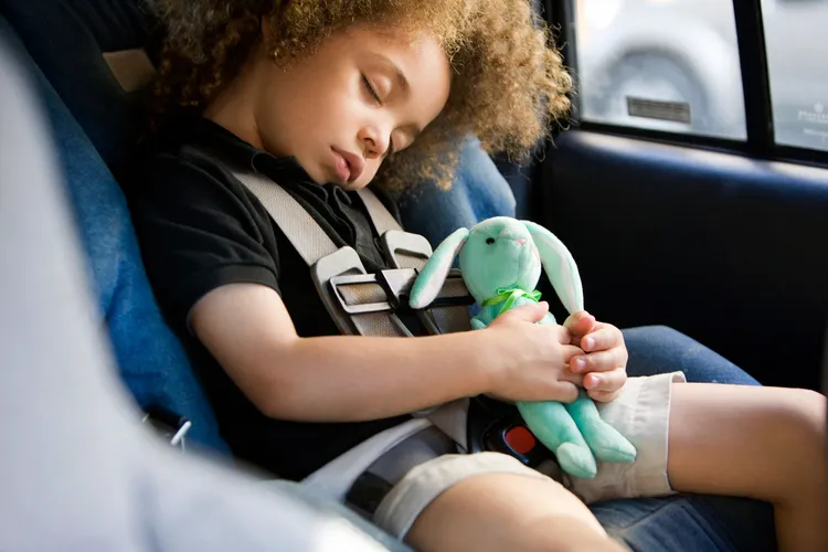 photo of Mixed-race boy sleeping in car seat