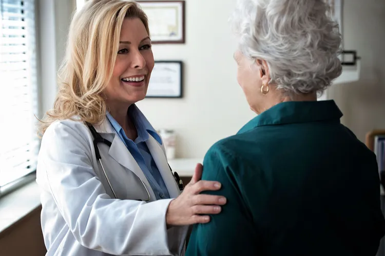 photo of Doctor talking to a senior patient in a c