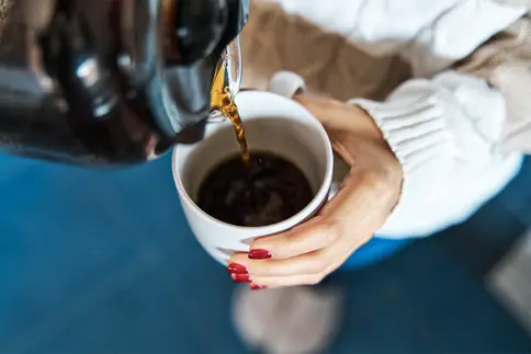 photo of woman pouring herself hot filter coffee