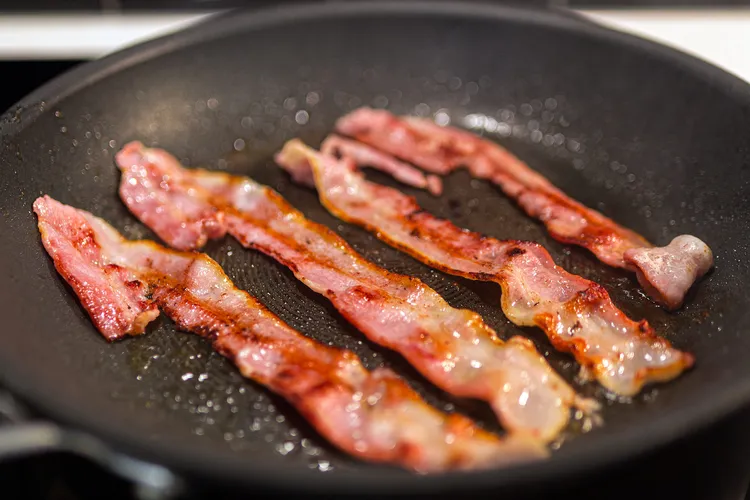 photo of bacon strips being fried