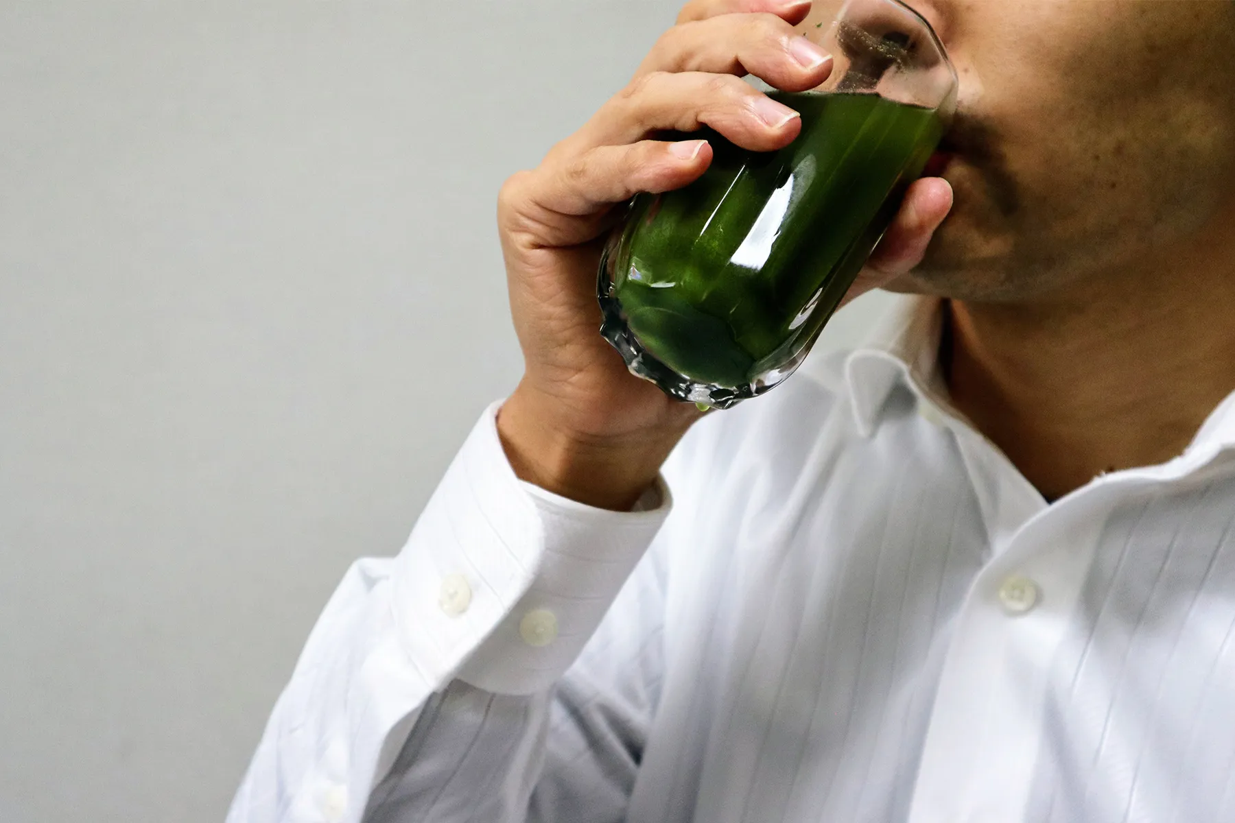 photo of person drinking green juice