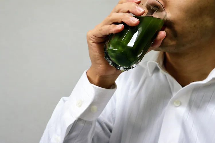 photo of person drinking green juice