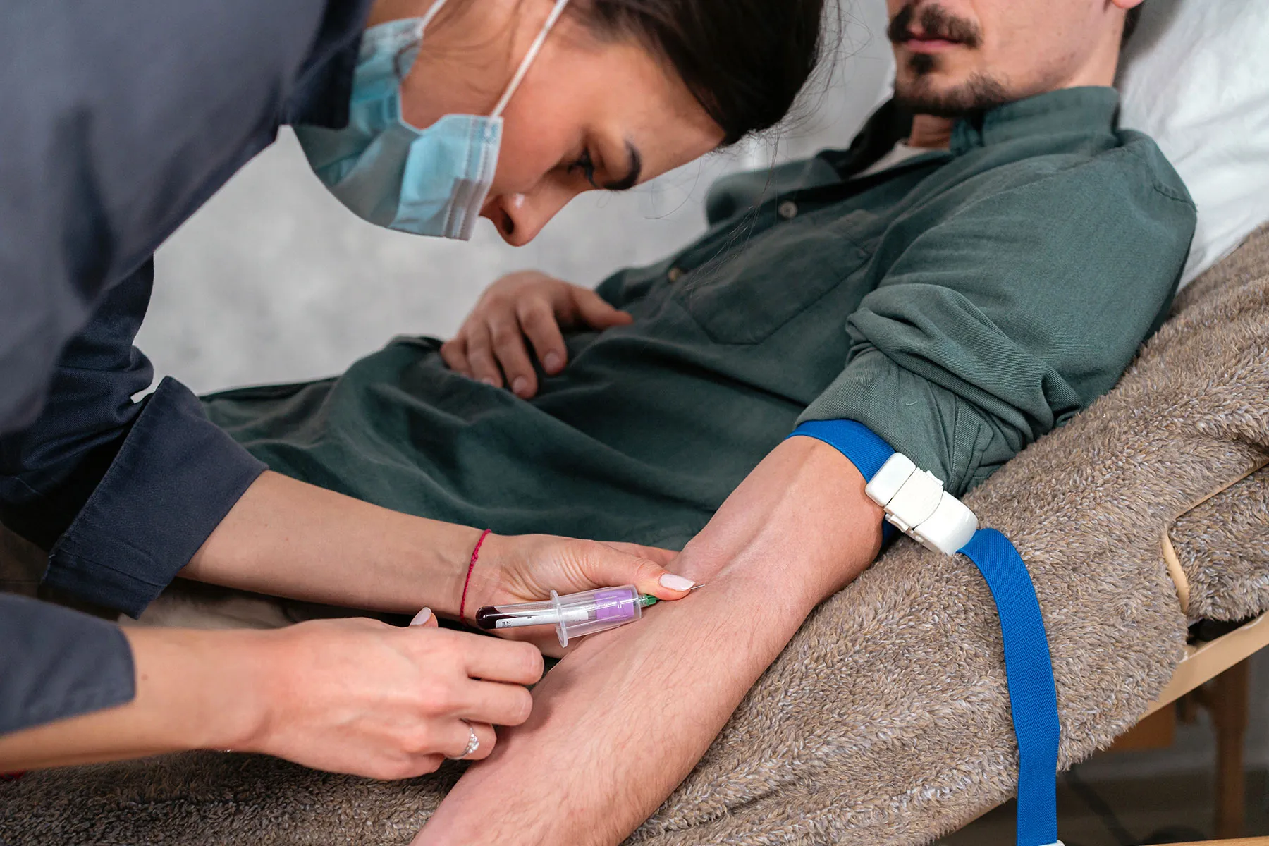 photo of nurse drawing blood from male patient