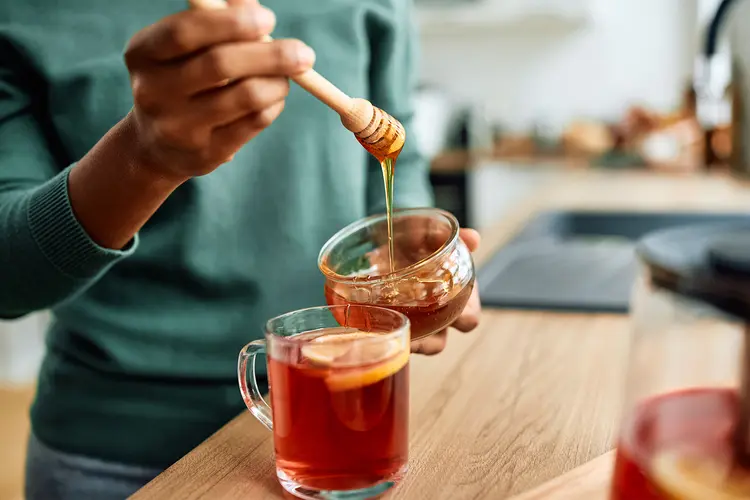 photo of woman drinking tea with honey at home