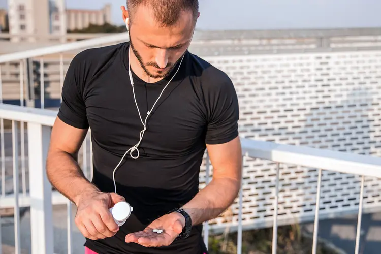 photo of athletic, young man taking supplements