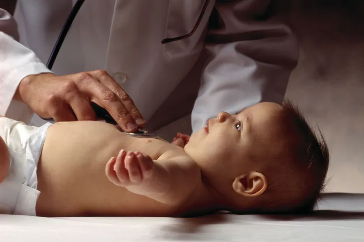 photo of Doctor examining an infant baby.