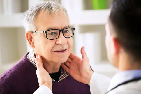 photo of doctor checking senior patient's lymph nodes
