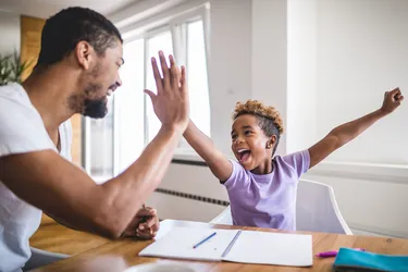 Praising your child for completing tasks is an example of positive reinforcement. (Photo credit: E+/Getty Images)