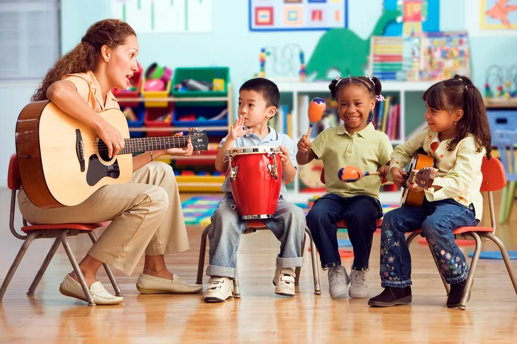 photo of teacher playing music with young children