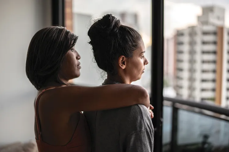 photo of couple looking out apartment window