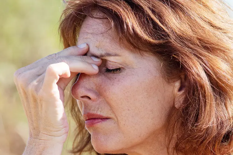 photo of woman massaging sinuses