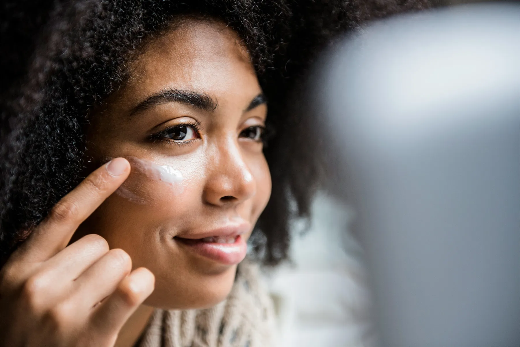 photo of woman applying sunscreen