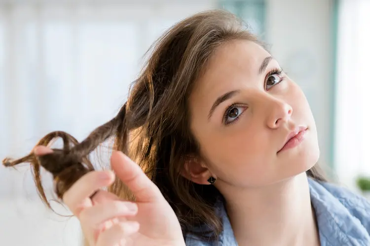 photo of young woman twirling hair