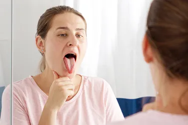 A healthy tongue is pink and covered in papillae. Color and texture changes could be a sign of a health condition. (Photo Credit: iStock/Getty Images)