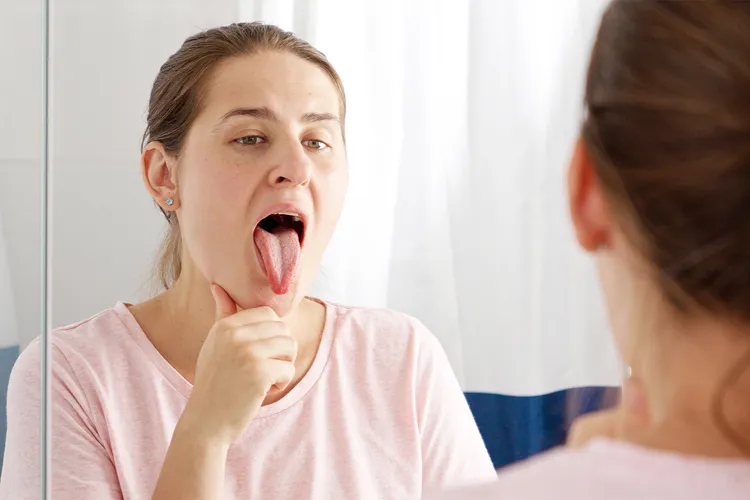 photo of young woman checking her teeth and tongue