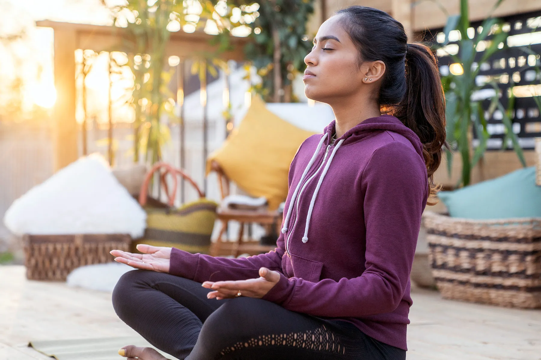 photo of woman meditating on patio