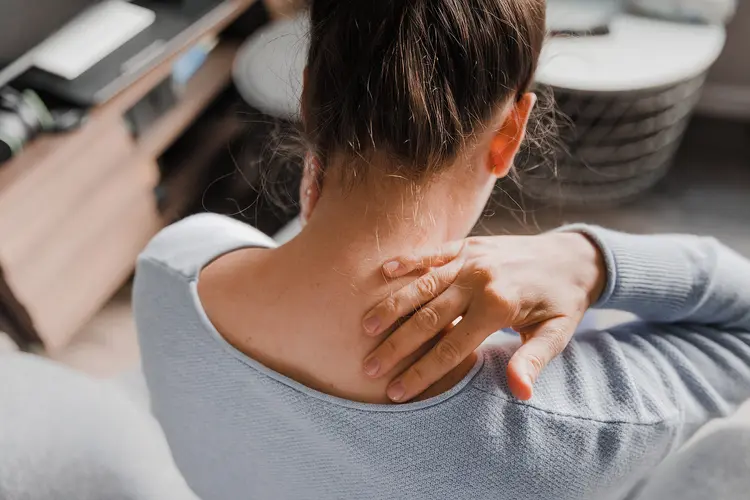 photo of woman massaging her stiff neck