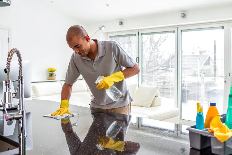 photo of man cleaning kitchen counter