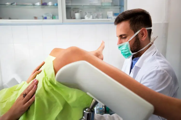 photo of Gynecologist examing his patient 