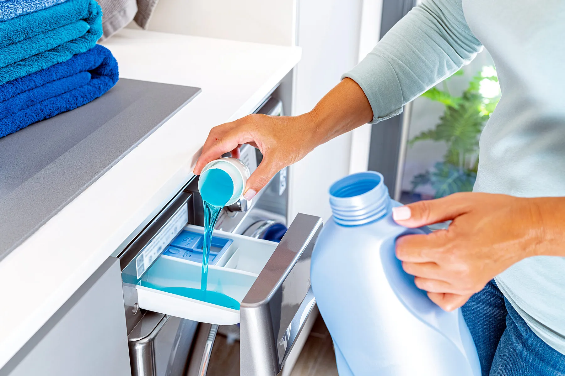 photo of woman adding fabric softener to wash