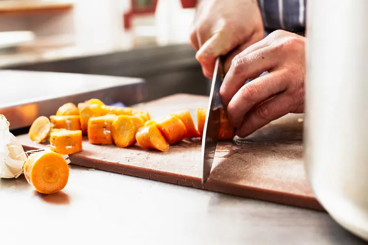 photo of Close up of chef chopping carrots