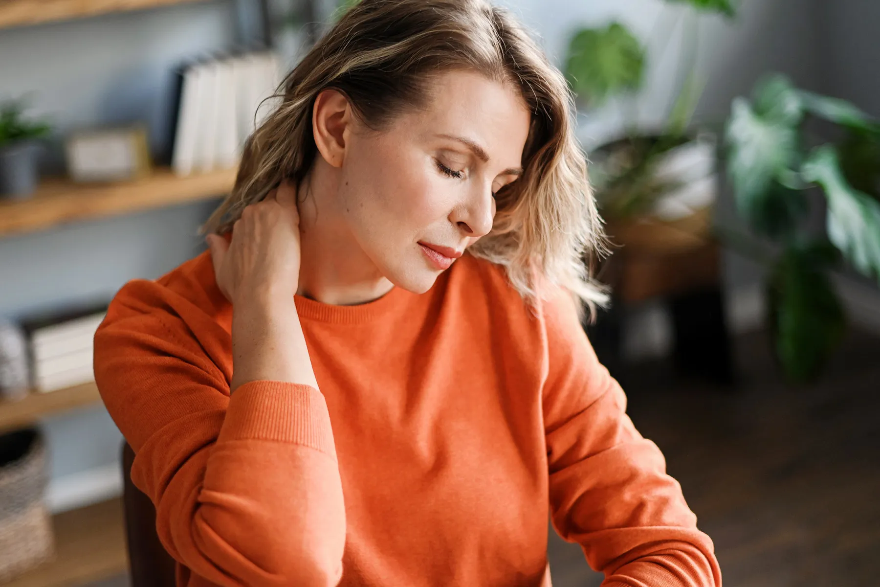 photo of woman rubbing sore neck