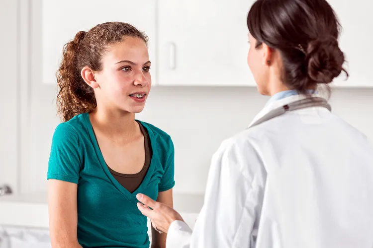 photo of pre-teen girl talking with doctor