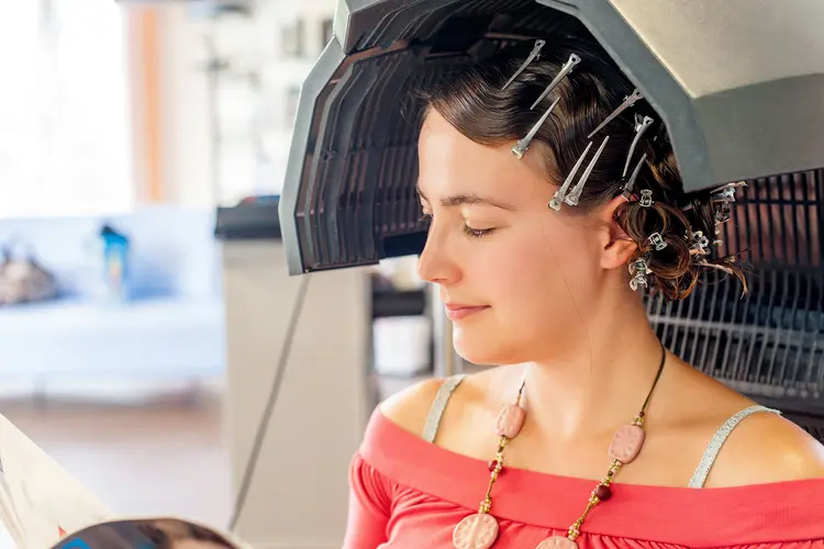 photo of woman under hair dryer in salon