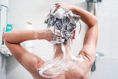 photo of Woman washes her hair with shampoo