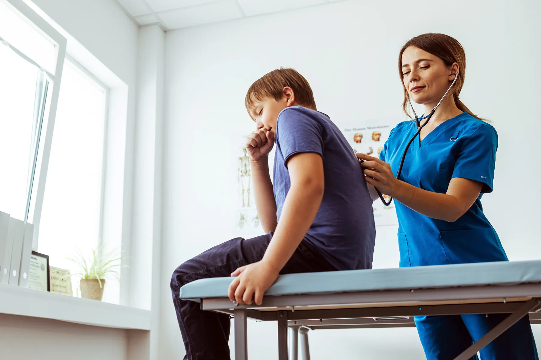 photo of boy coughing during doctor exam